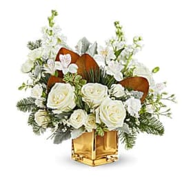 White rose arrangement in a gold vase with white orchids and greenery
