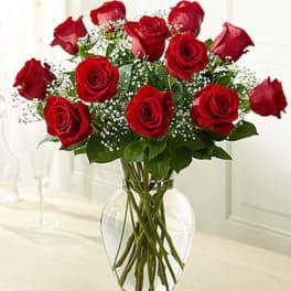 Red roses arranged in a clear glass vase