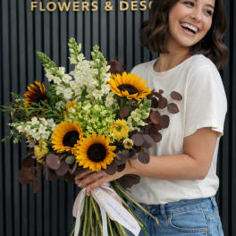 Woman holding a bouquet of sunflowers and white flowers