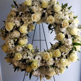 Cream and white floral wreath on a black stand