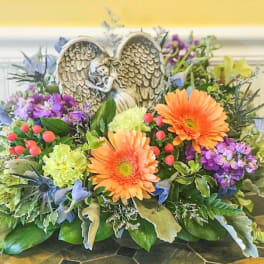 Colorful floral arrangement with an angel figurine centerpiece