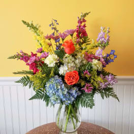 Colorful mixed flower arrangement in a clear glass vase