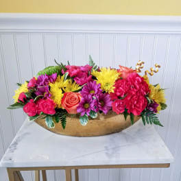 Bright mixed flower arrangement in a gold bowl