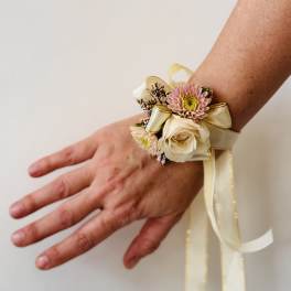 Wrist corsage with cream rose, pink daisy, and ribbon ties