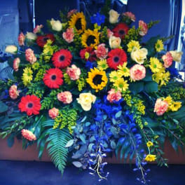 Large floral spray with sunflowers, gerbera daisies, and roses