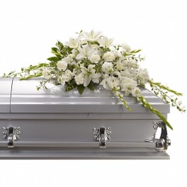 White floral casket spray on a silver casket