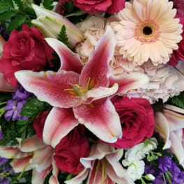 Bouquet of pink lilies, roses, and daisies in mixed colors