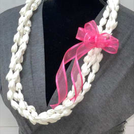 Double-strand white floral lei with a pink ribbon bow displayed on a mannequin