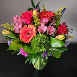 Mixed bouquet of pink and red flowers in a glass vase