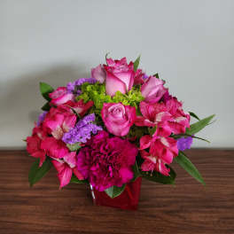Pink roses and alstroemeria in a red vase