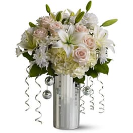 White lilies, pale roses, and hydrangeas in a mirrored vase with silver ribbons