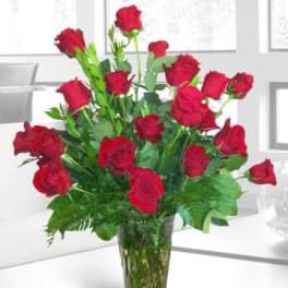 Red roses arranged in a clear glass vase