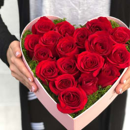 Heart-shaped box of red roses held in two hands
