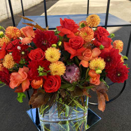 Bright red and orange mixed bouquet in a clear glass vase