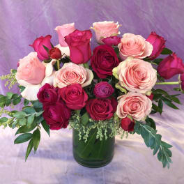 Pink and red roses arranged in a glass vase