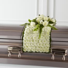 White floral casket spray with roses and chrysanthemums