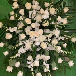 Large white floral spray with roses and orchids against green tiles