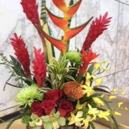 Tropical floral arrangement with red roses and orange bird-of-paradise blooms