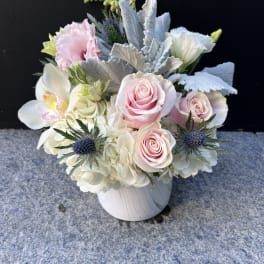 Pink roses and white orchids in a white vase