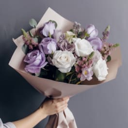 Bouquet of lavender and white roses wrapped in blush paper