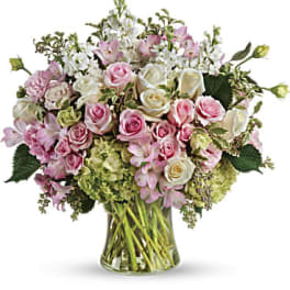 Pastel pink and white flower arrangement in a clear glass vase