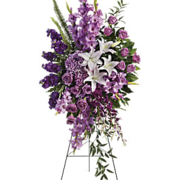Tall purple and white funeral spray on a stand