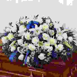 White floral arrangement with blue and yellow accents in a vase
