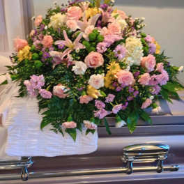 Pastel floral spray on a silver casket