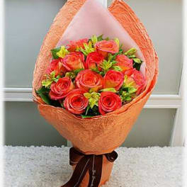 Bouquet of orange and red roses wrapped in peach paper
