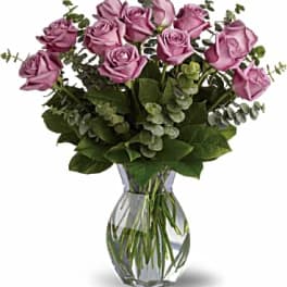 Lavender roses arranged in a clear glass vase