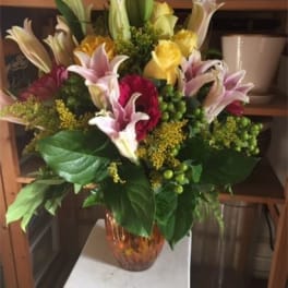 Mixed bouquet of lilies and roses in a glass vase