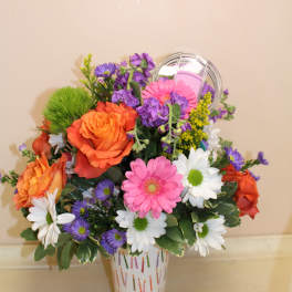 Colorful mixed flower arrangement in a patterned vase