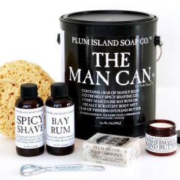 Gift set with soap, shaving gel, body butter, and a sponge in a black tin
