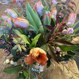 Bouquet of fringed tulips and mixed foliage on a table