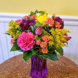 Colorful mixed bouquet in a purple glass vase