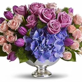 Lavender roses and blue hydrangea in a silver pedestal vase