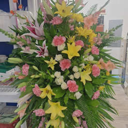 Tall standing floral spray with lilies, carnations, and pink snapdragons