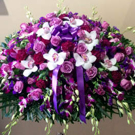 Large purple and white floral spray with ribbon accents