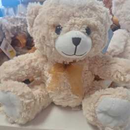 Plush teddy bear with a gold ribbon bow