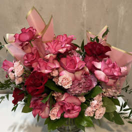 Pink and red rose bouquet in a glass vase with pink wrap