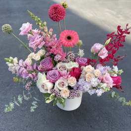 Mixed pink and white floral arrangement in a white vase