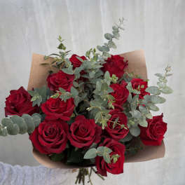 Bouquet of red roses with eucalyptus wrapped in brown paper