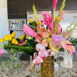 Two colorful floral arrangements in vases on a kitchen counter