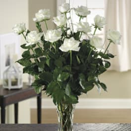 White roses arranged in a clear glass vase