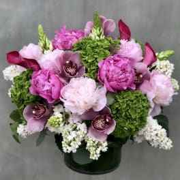 Pink and white floral arrangement in a dark vase