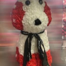 Dog-shaped floral arrangement with red and white flowers and a black ribbon