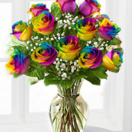 Rainbow roses arranged in a clear glass vase