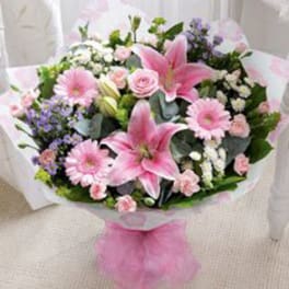 Pink lilies and mixed pastel flowers wrapped in white paper