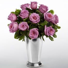 Lavender roses arranged in a silver vase