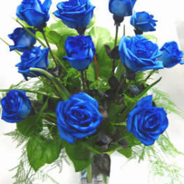 Bouquet of vivid blue roses in a clear glass vase